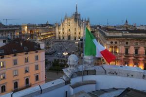 米兰PRESTIGE BOUTIQUE APARTHOTEL - Piazza Duomo View的建筑上两面旗帜的城市景观