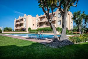 托里代巴拉AT015 Els Munts的公寓大楼设有游泳池和棕榈树