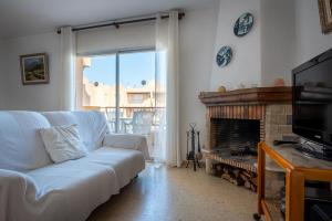 托里代巴拉AT015 Els Munts的客厅配有白色沙发和壁炉