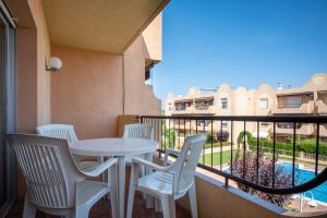 托里代巴拉AT015 Els Munts的一个带桌椅的阳台和一个游泳池