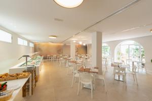 贝尼多姆国际酒店的餐厅设有白色的桌椅和窗户。