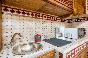 丹吉尔Dar Sandra Moroccan Tiny House的厨房柜台设有水槽和微波炉