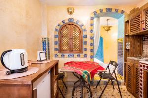 丹吉尔Dar Sandra Moroccan Tiny House的厨房配有桌子和微波炉