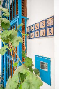 丹吉尔Dar Sandra Moroccan Tiny House的大楼的蓝色门和标志