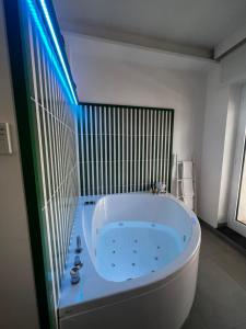 圣安吉洛Al Campanile的浴室设有蓝色的灯光,配有大型白色浴缸。