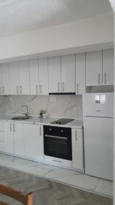 奥赫里德Flat in Trpejca的厨房配有白色橱柜和黑烤箱。