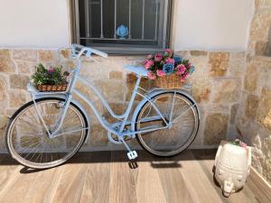 莫诺波利Il Casale Di Kevin的蓝色自行车,上面有两篮子和鲜花