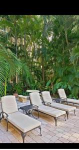 棕榈滩Tropical Palm Beach 2 Bedroom 2 Bathroom Suite POOL -BEACH 2 Blocks Valet Parking Included的庭院里一排桌椅