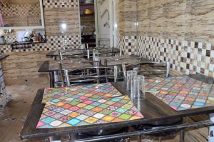 穆索里Bhandari Homestay and Restaurant的餐厅设有桌椅和色彩缤纷的垫子
