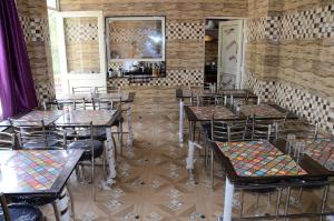 穆索里Bhandari Homestay and Restaurant的一间在房间内配有桌椅的餐厅