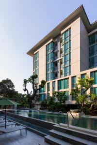 清迈ANA Park Chiang Mai的一座建筑前面设有游泳池