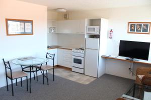 纳鲁马纳鲁马棕榈度假公寓酒店的小厨房配有桌子和电视。