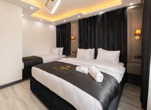 特拉布宗Selia SUİTES的酒店客房,配有两张带白色床单的床