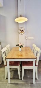 马拉加Malaga Lodge Apartments的餐桌、白色椅子和灯具
