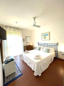 莱乌卡Dimora dei pini的卧室设有一张白色大床和一扇窗户。