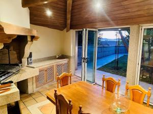 维戈Villa overlooking Cies Islands的厨房配有木桌和大型玻璃门。