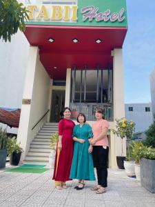 岘港塔比伊酒店的三名妇女站在旅馆前