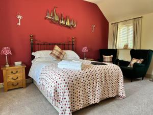 纳伯斯Canaston Oaks的一间卧室设有一张床和红色的墙壁