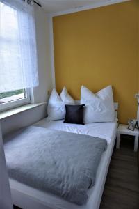 伊尔梅瑙Ferienwohnung TrautesHeim - Parkplatz gratis的窗户客房内的一张带白色枕头的床