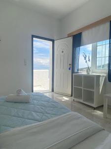 Vagia蓝色海豚公寓的白色的卧室设有床和大窗户