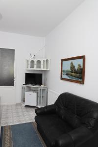 培拉特Villa Deart Berat的客厅设有一张黑色皮沙发,配有电视