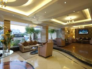 科威特科威特法哈希尔波德酒店的大楼内一个带沙发和电视的大堂