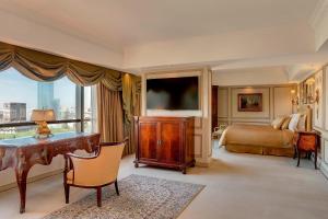 布宜诺斯艾利斯布宜诺斯艾利斯公园大厦豪华精选酒店的一间卧室配有书桌、一张床和一台电视。
