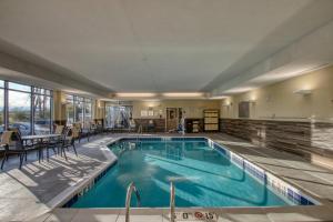 阿普尔顿Fairfield Inn & Suites by Marriott Appleton的游泳池位于酒店客房内,配有桌椅