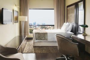 拉合尔Four Points by Sheraton Lahore的配有一张床、一张书桌和一扇窗户的酒店客房