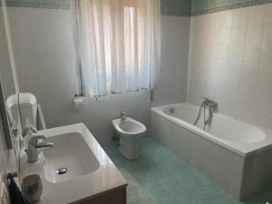 诺阿莱White Smile Apartment的带浴缸、卫生间和盥洗盆的浴室