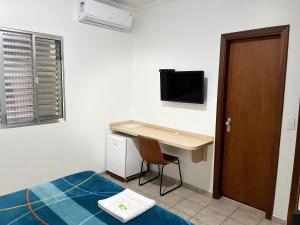 坎皮纳斯Hotel Taquaral的一间卧室配有书桌、一张床和一张书桌