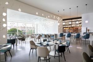 利雅德Le Meridien Riyadh的餐厅设有桌椅和大窗户。