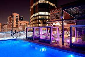阿布扎比阿布扎比万豪国贸中心庭院酒店的一座带紫色椅子的屋顶游泳池和一座建筑