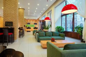 布达佩斯布达佩斯市中心万豪庭院酒店的客厅配有绿色沙发和桌子