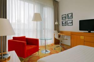 布达佩斯布达佩斯市中心万豪庭院酒店的酒店客房设有红色椅子和电视