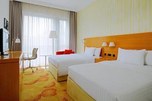 布达佩斯布达佩斯市中心万豪庭院酒店的酒店客房设有两张床、一张桌子和一台电视。