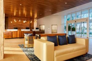 坎昆Fairfield Inn & Suites by Marriott Cancun Airport的带沙发和酒吧的客厅