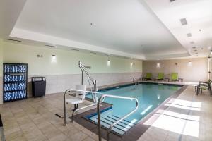 俄克拉何马城俄克拉荷马市中心万豪思普瑞和酒店的游泳池,带桌椅的房间