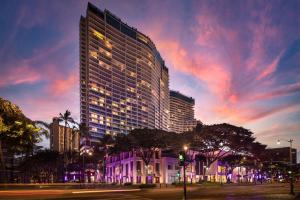 檀香山威基基海滩丽思卡尔顿公寓式酒店的一座高大的建筑,城市里灯火通明