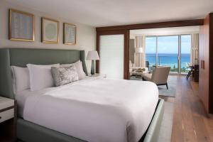 檀香山威基基海滩丽思卡尔顿公寓式酒店的卧室设有一张大白色床,享有海景