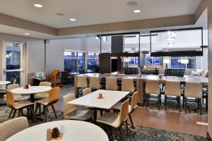 克拉尔维尔Residence Inn by Marriott Coralville的用餐室设有桌椅和窗户。