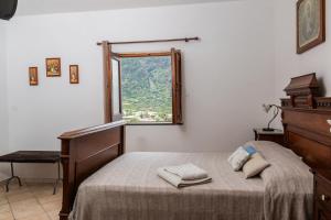 马尔法Agriturismo Al Cappero的一间卧室配有一张床、一张书桌和一个窗户。
