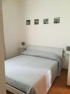 卡斯蒂利翁切洛Appartamento Bellavista的墙上挂着照片的白色床
