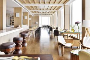 勒克瑙勒克瑙万丽酒店的餐厅设有木桌和椅子以及长长的走廊