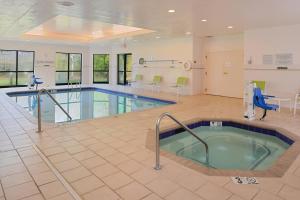 加斯托尼亚夏洛特加斯托尼亚万怡酒店的医院里的一个游泳池,有带椅子的等候室