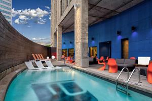 达拉斯雅乐轩达拉斯市中心酒店的一座带橙色椅子和家具的游泳池