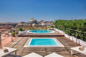 那不勒斯地中海那不勒斯万丽酒店的一座带游泳池的庭院,位于一座建筑的顶部
