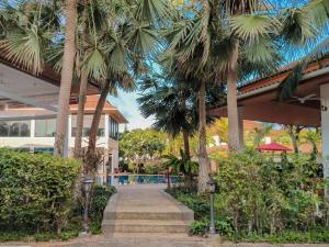 拉威海滩Rawai Grand House -SHA Plus的棕榈树度假村,毗邻游泳池