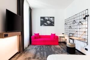 维尔茨堡Moxy Wuerzburg的客厅配有红色沙发和电视
