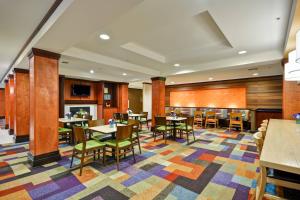 富尔顿戴尔伯明翰富尔顿戴尔/I-66费尔菲尔德万豪套房酒店的一间设有桌椅的餐厅,铺着色彩缤纷的地毯